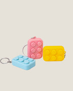 3D printed bubble pop clicker keychains in pink, yellow and blue