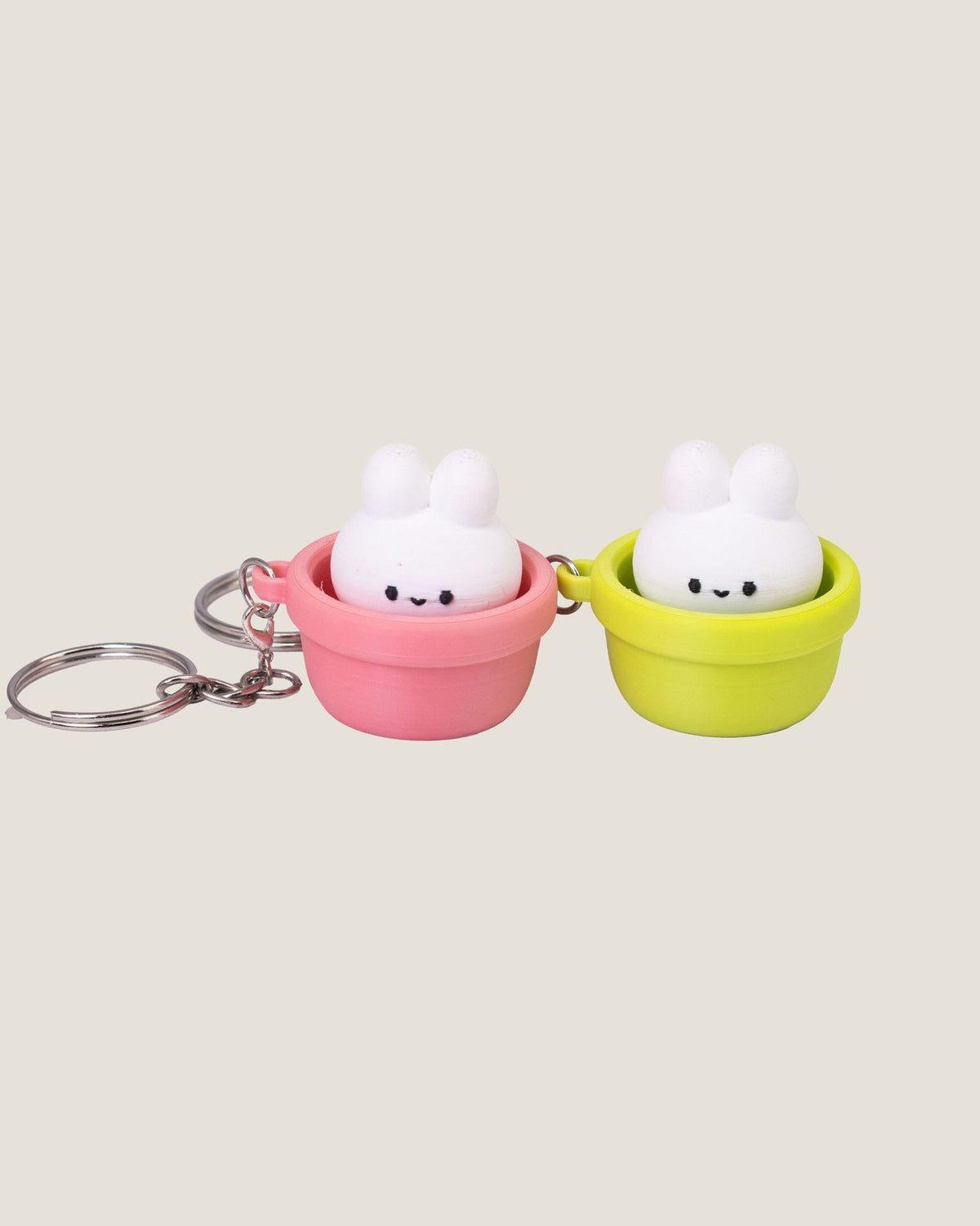 3D printed bunny in a pot clicker keychains in pink and green