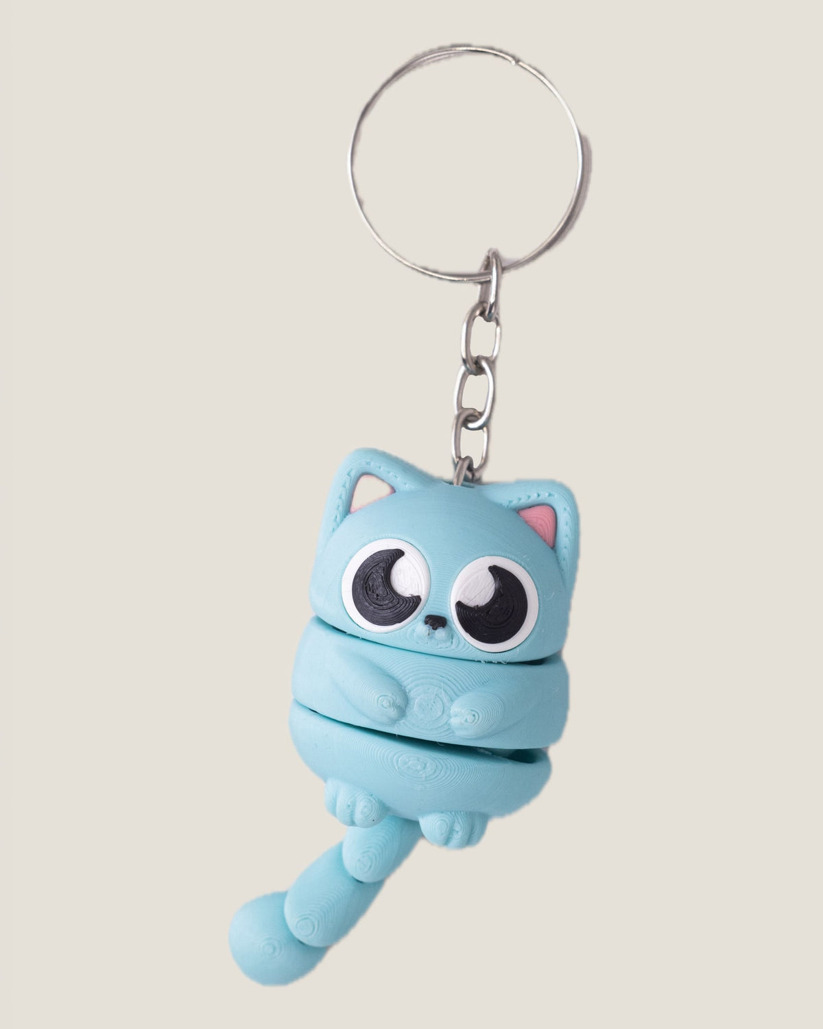 3D printed flexi cat keychains in pink, yellow and blue