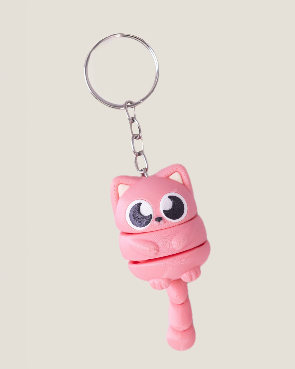 3D printed flexi cat keychains in pink, yellow and blue