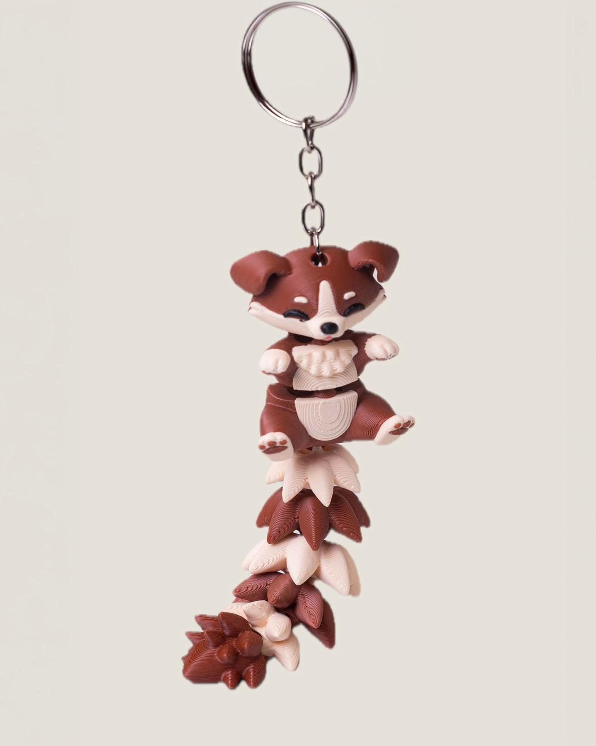 3D printed flexi puppy keychain with a long fluffy jointed tail