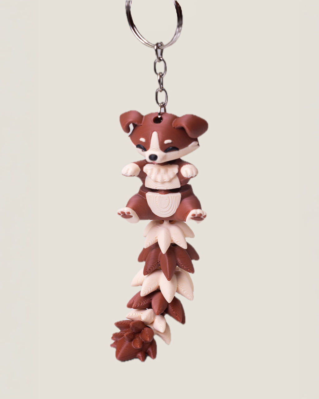 3D printed flexi puppy keychain with a long fluffy jointed tail