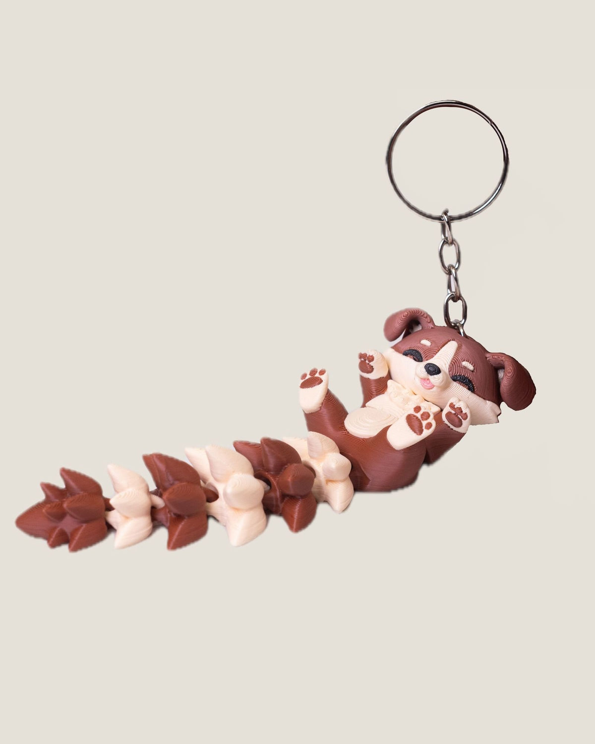3D printed flexi puppy keychain with a long fluffy jointed tail