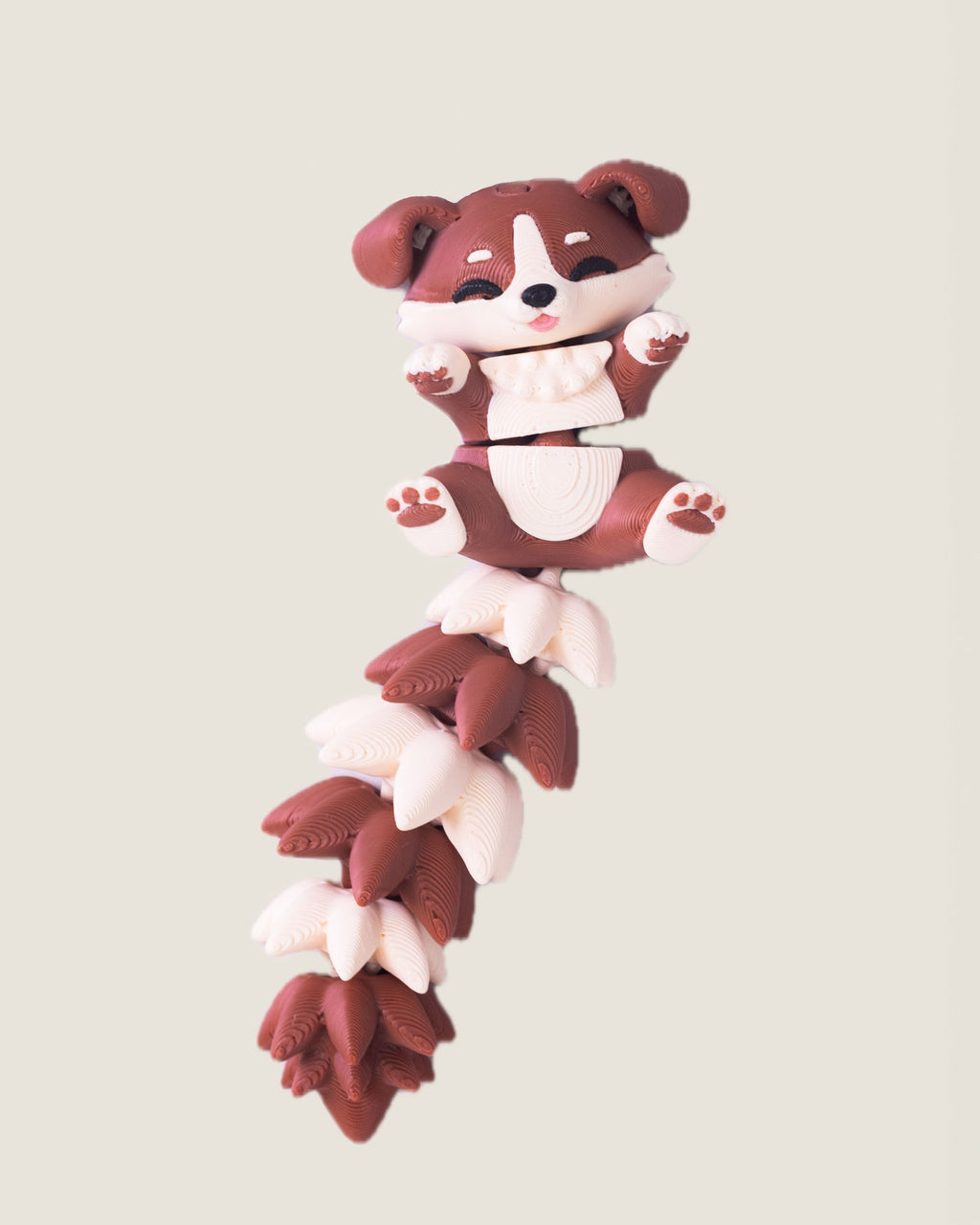 3D printed flexi puppy keychain with a long fluffy jointed tail