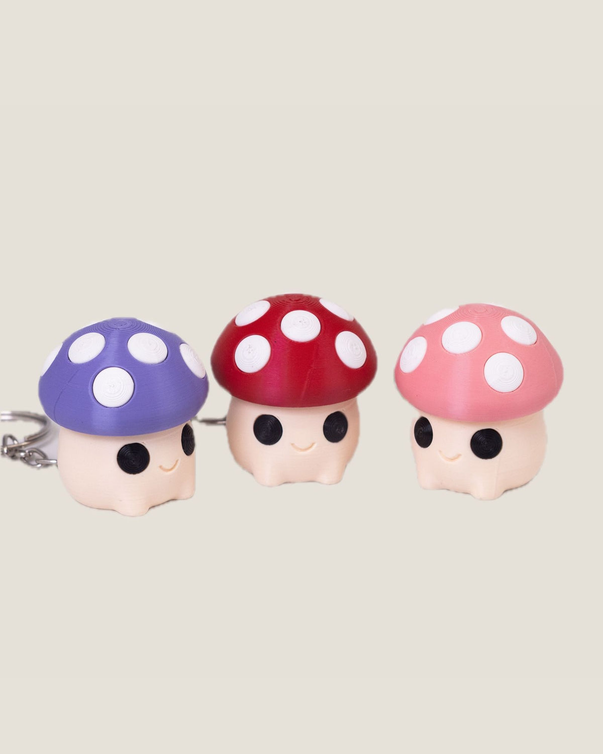 3D printed mushroom clicker keychains in purple, red and pink