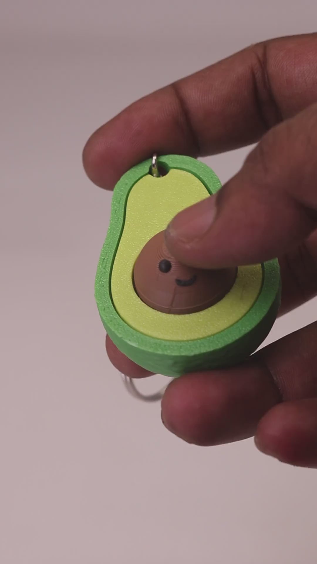 3D printed avocado clicker keychain with a smiling seed