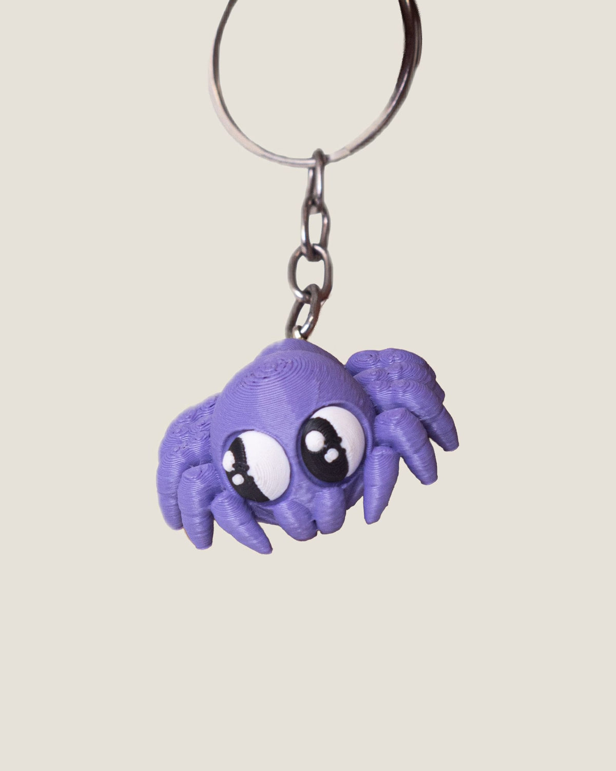3D printed purple jiggly spider keychain with big eyes